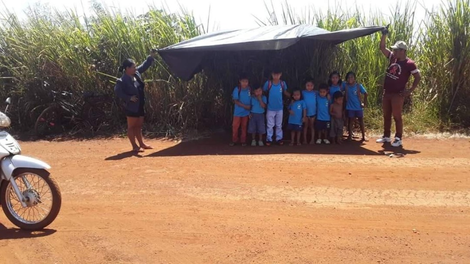 Em Douradina, pais improvisam “Ponto de Ônibus” de lona para proteger alunos do Sol
