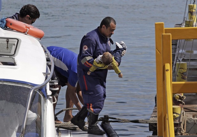Embarcação da travessia Salvador-Mar Grande vira na Baía de Todos-os-Santos; número de mortos sobe para 22 Socorrista do Samu leva um bebê no colo após uma embarcação naufragar em Mar Grande, na Baía de Todos-os-Santos, na Bahia (Foto: Xando Pereira/Agência A Tarde/Estadão Conteúdo)