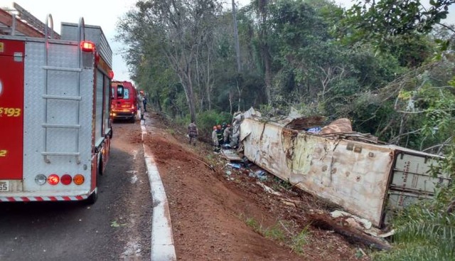 Caminhões batem, um cai na ribanceira e motorista fica preso nas ferragens Caminhões batem, um cai na ribanceira e motorista fica preso nas ferragens