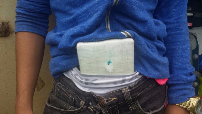 Ainda em vistoria ao ônibus, foi localizado na cintura do menor D.R.R., 1 tablete de cocaína que totalizou 1 quilo da droga.