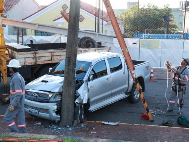 Motorista bate caminhonete em poste e foge do local de acidente Frente do veículo ficou destruída; funcionários da Energisa trabalham na troca do poste (Foto: Henrique Kawaminami)